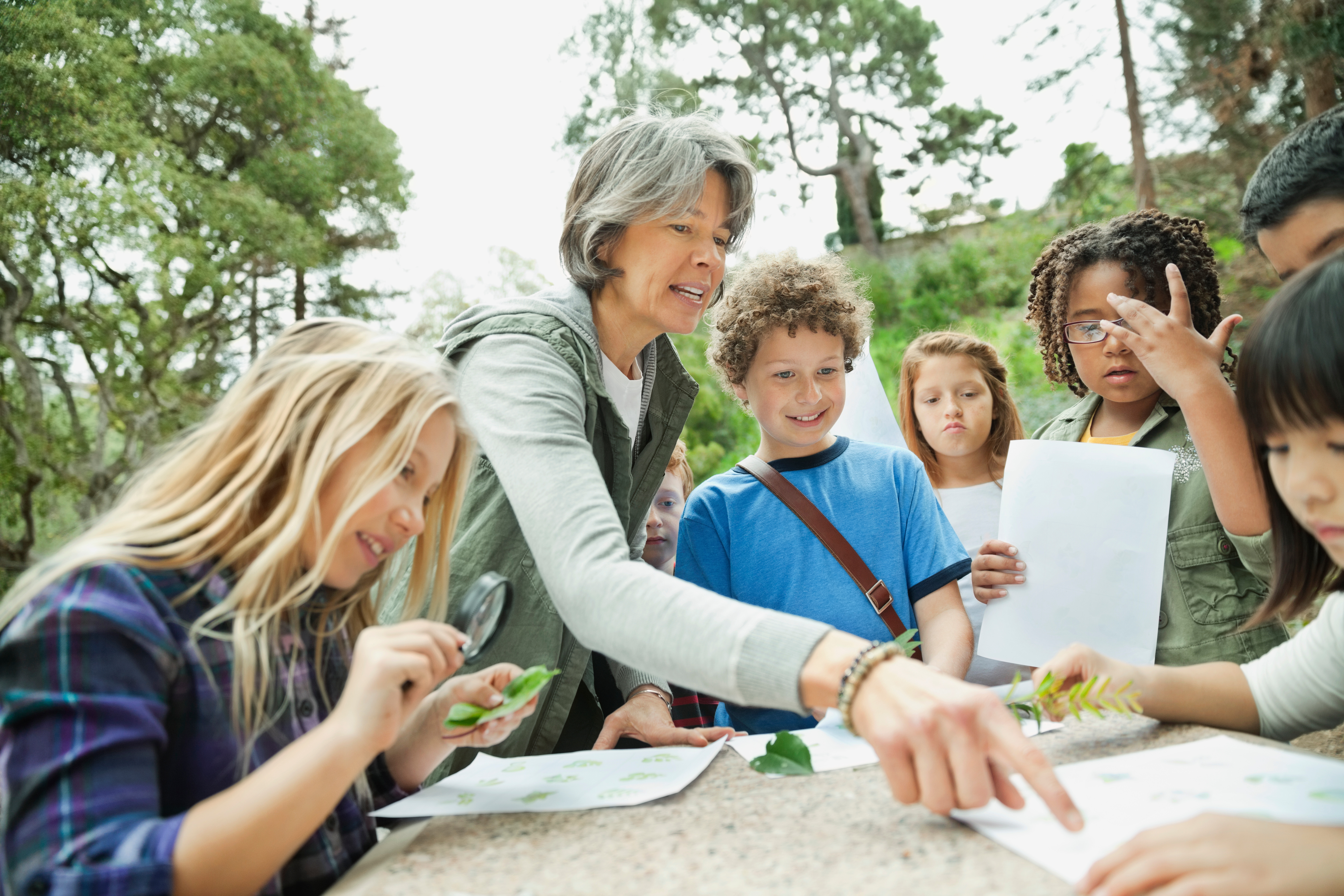 Teacher assisting students with assignment during field trip